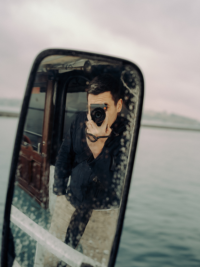 Sam Lipscomb photographing himself in a boat mirror on the water
