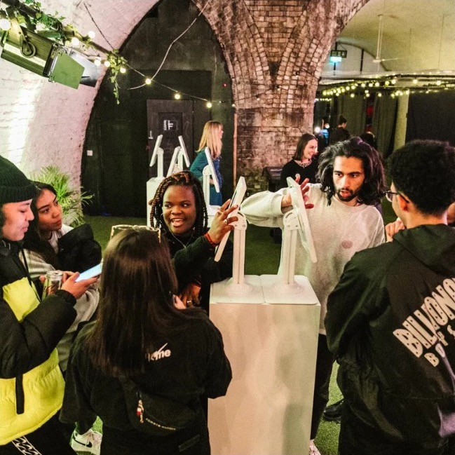 Young rap fans and Sony Music staff talking at the Pave launch event in a railway arch